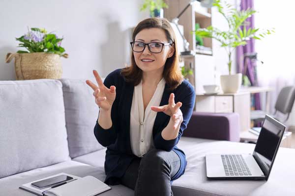 A psychologist sitting with a laptop, talking to the camera