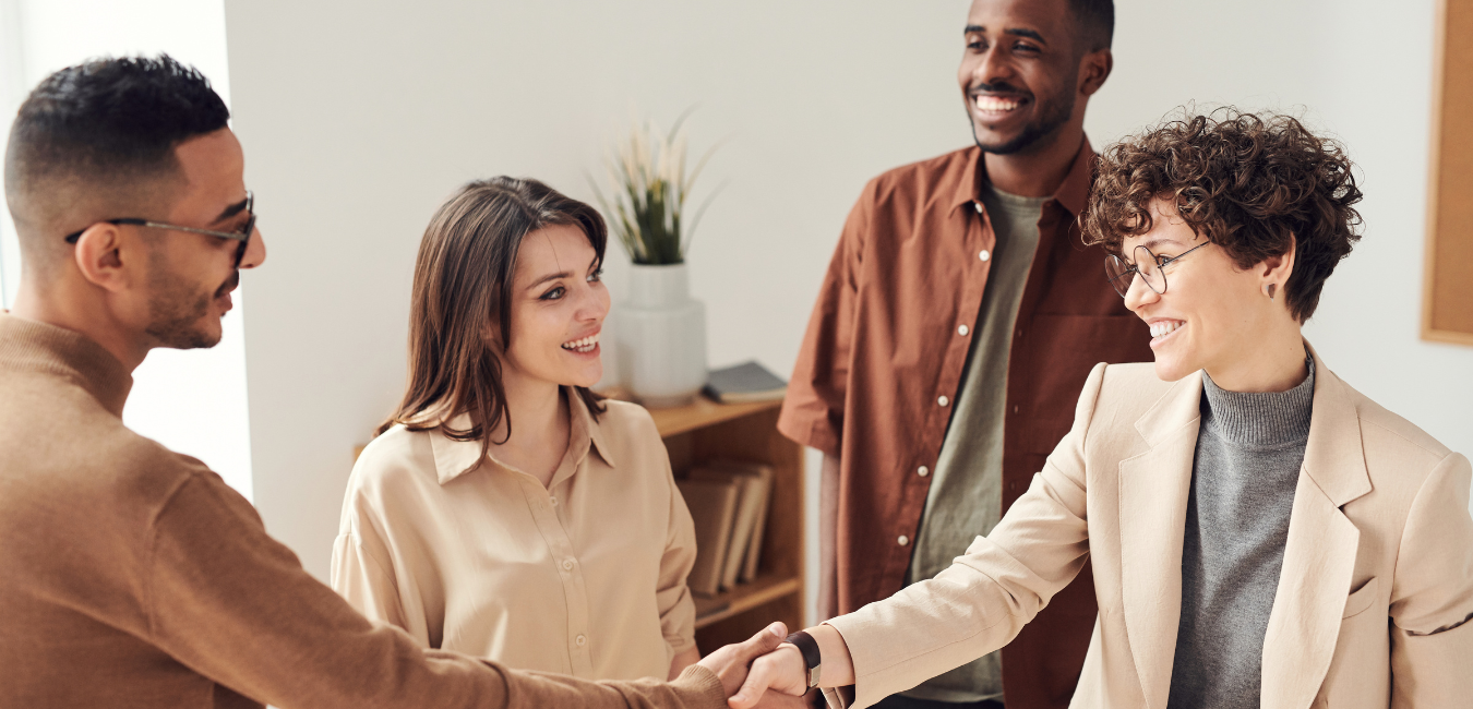 Two men and two women meeting each other and shaking hands