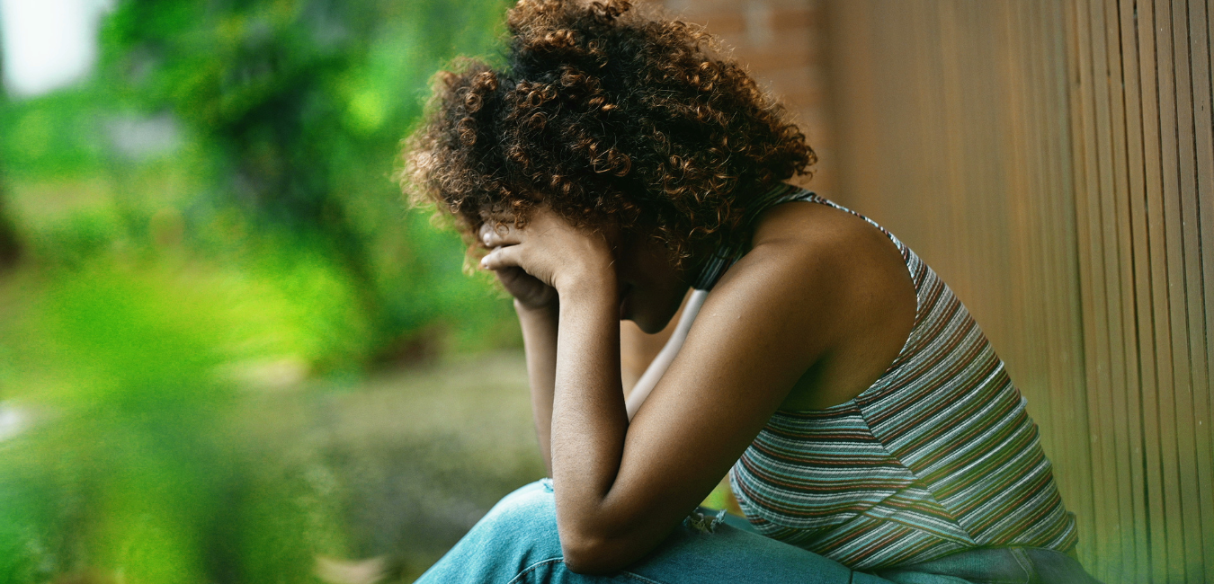 A woman with her head in her hands coping with grief.